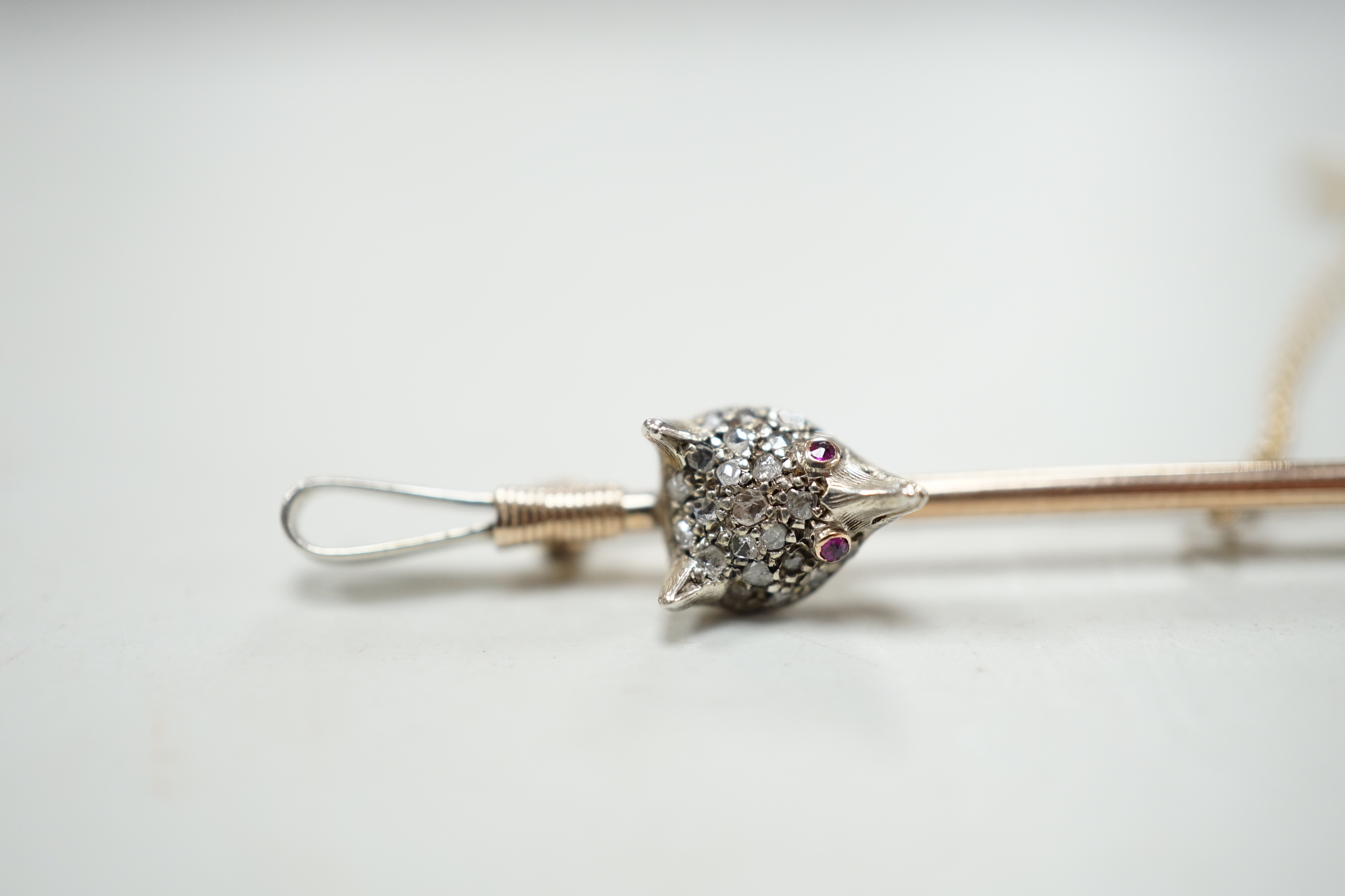 An Edwardian yellow metal, sapphire and diamond cluster fox head and riding crop bar brooch, with ruby set eyes, 52mm, gross weight 4.1 grams, in fitted box.